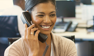 Smiling woman on the phone in an office