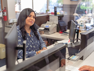 Person behind the counter as a bank teller helping a customer