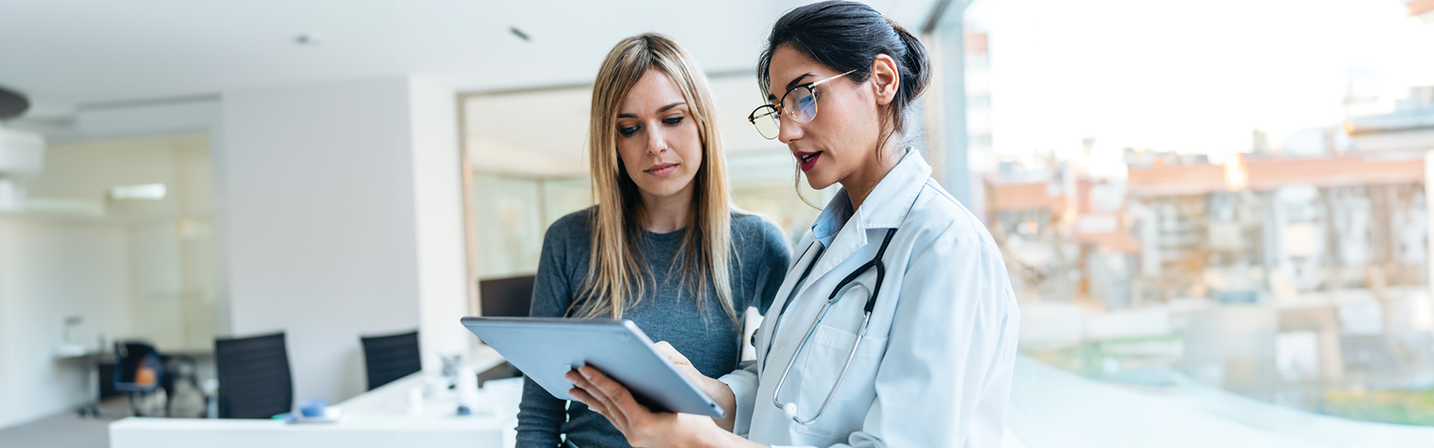 Female doctor showing a female patient her test results on a tablet