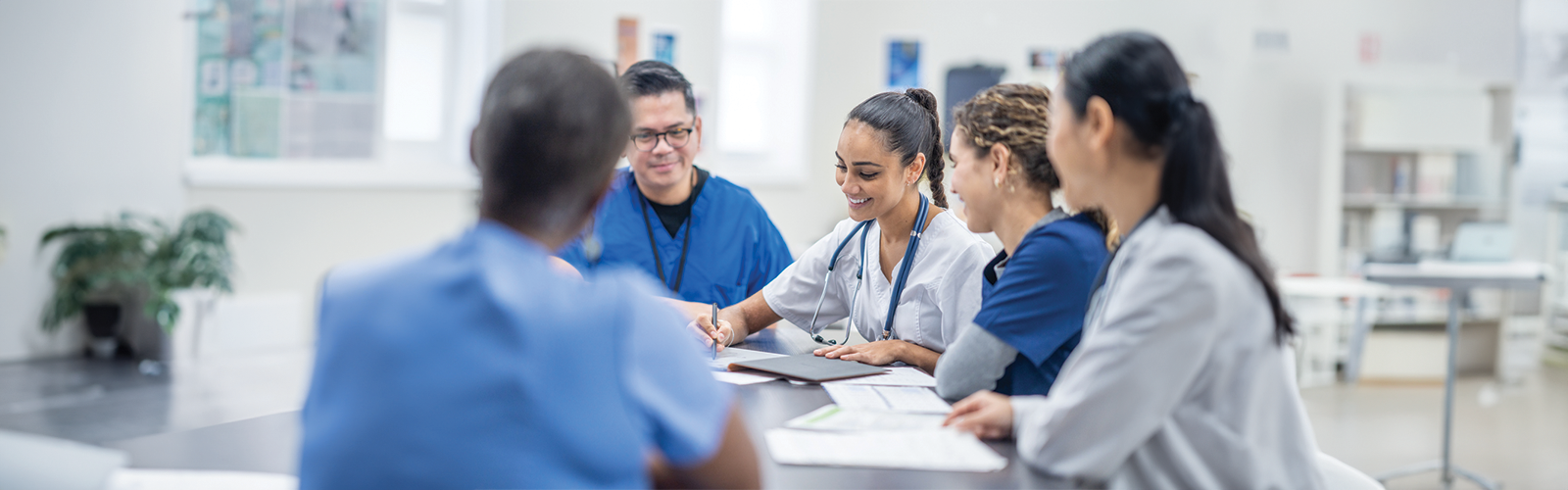 Group of doctors sitting around a table looking over documents