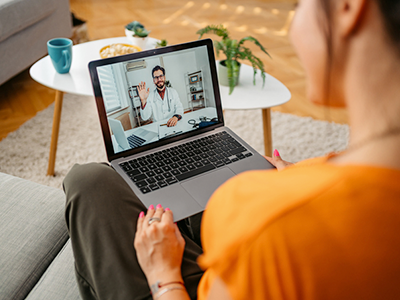 Patient at home on their laptop having a video call with their doctor