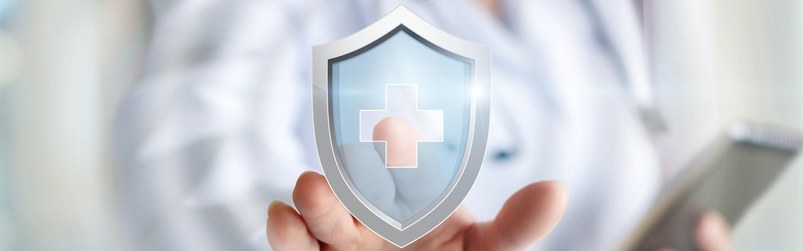 Image of a doctor tapping a shield icon with a logo of a medical cross inside of it