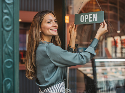 Woman flipping the open sign on her business door