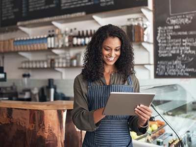 Woman working in a coffee shop using a tablet