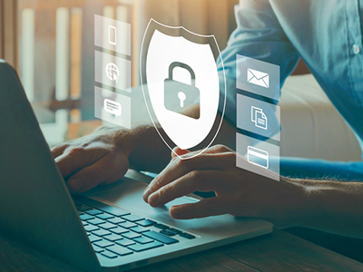 A man on a laptop with a lock and shield graphic over the top