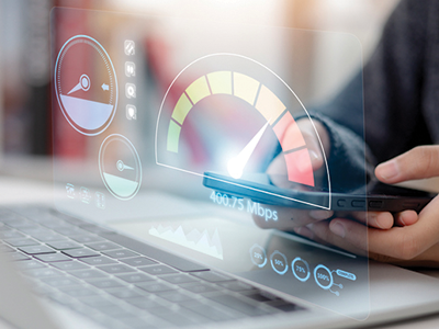 Pair of hands on a laptop with a graphic of an internet speed test