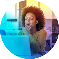 Smiling young black woman looking at laptop