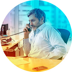 Middle aged white man sitting at a desk on a business phone