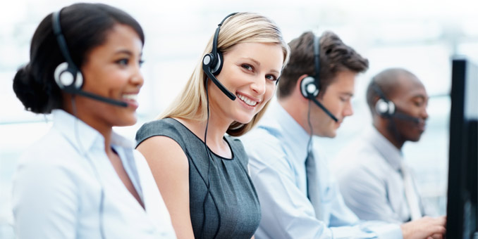 Four customer service individuals of mixed genders and race wearing telephone headsets